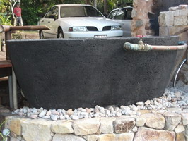 large outdoor bath, black scoria lava stone finish