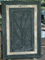 Charcoal lava stone finish wall plaque with travertine tile insert and reed pattern relief