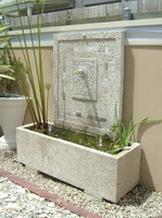 Custom lava stone water feature troughs and spouts with travertine tile inserts, off white finish